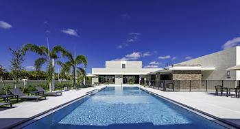 A modern house with a pool in the foreground.